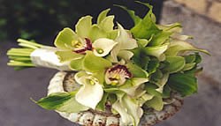 green and orchid wedding bouquet on pedestal.
