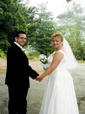 Bride and groom walking in forest.